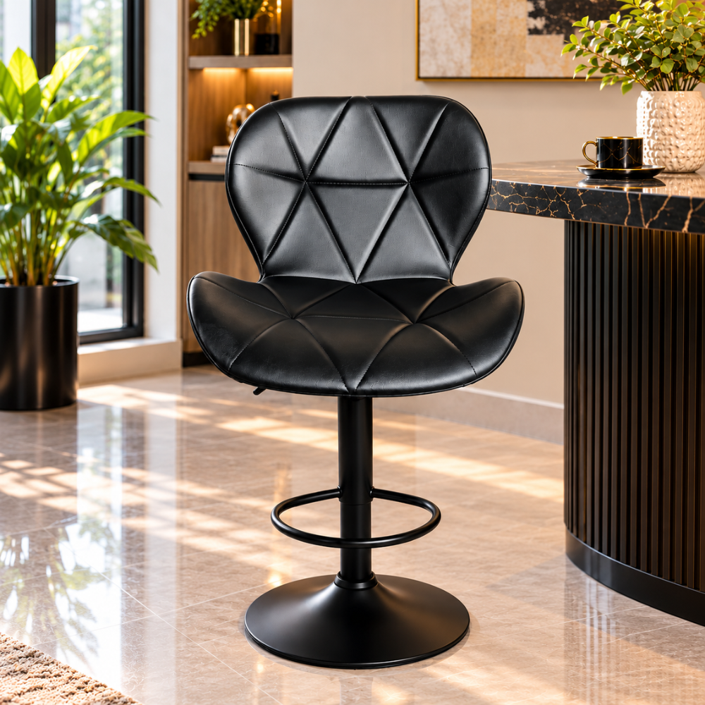 A black swivel barstool with a geometric diamond-patterned backrest and seat, set in a modern, sunlit interior next to a marble-topped counter.